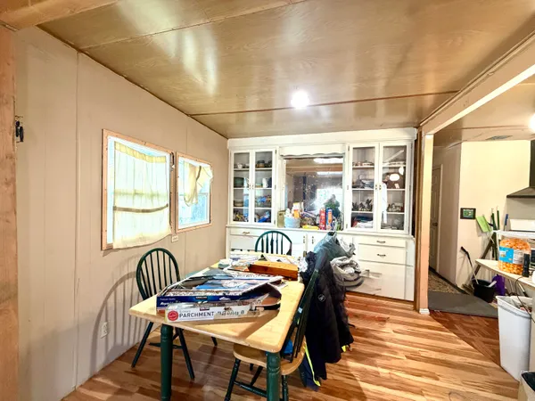 a kitchen with a refrigerator a stove a sink dishwasher and a dining table with wooden cabinet