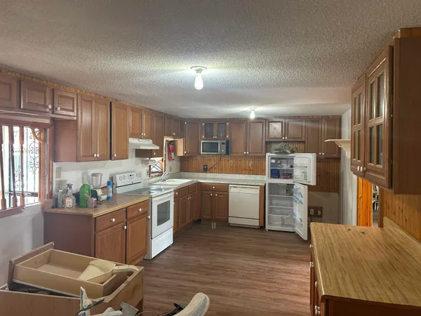 a kitchen with a sink refrigerator and microwave