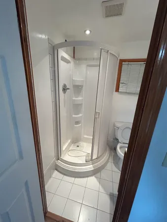 a bathroom with a glass door shower a toilet and sink