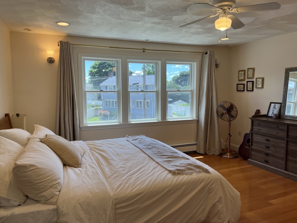 11 Garrison Road, Unit 1 Arlington, MA 02474 - Photo 27 of 42 a bedroom with a bed and a chandelier