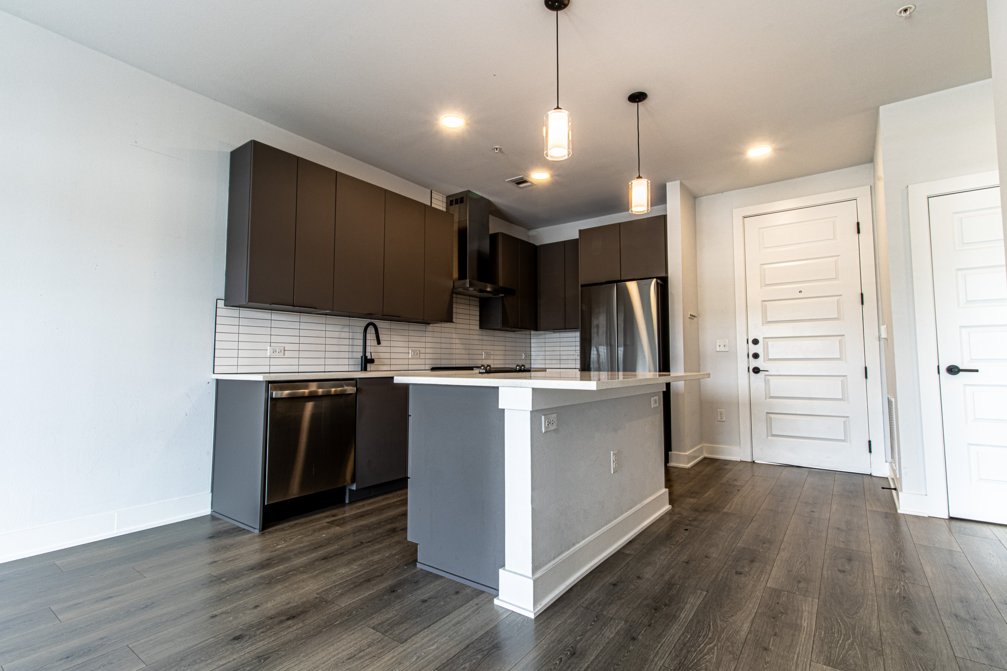 2220 Webberville Road, Unit 202 Austin, TX 78702 - Photo 10 of 27 Modern kitchen surfaces complement the dark wood flooring and clean design lines.