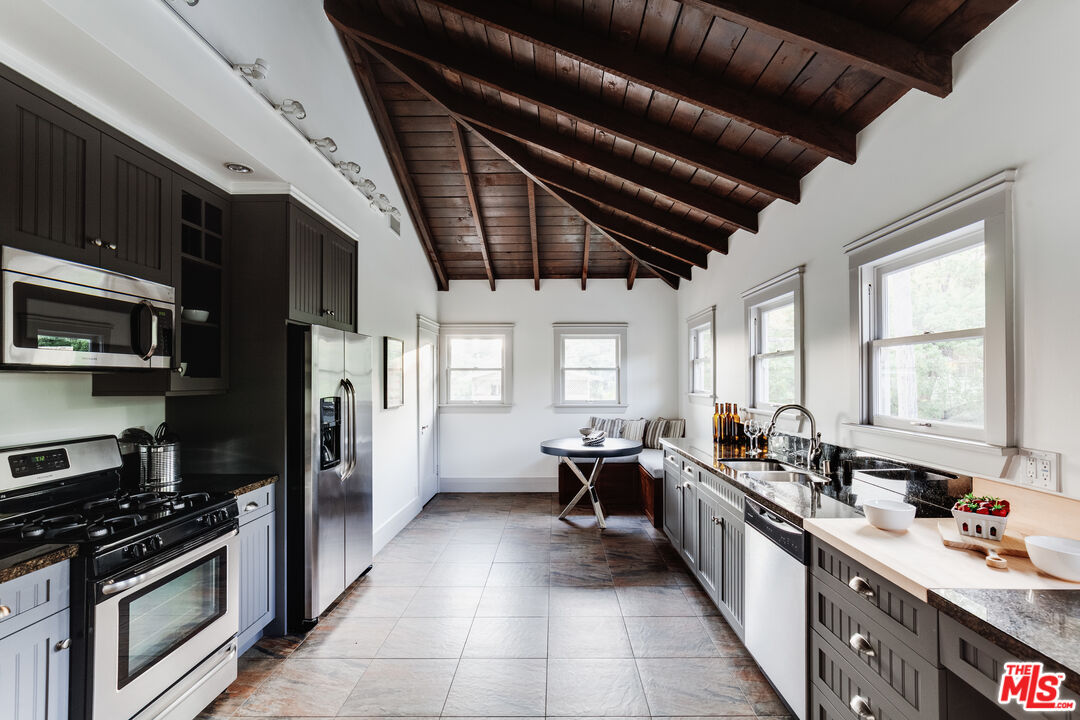 5850 Foothill Drive Los Angeles, CA 90068 - Photo 21 of 33 a kitchen with stainless steel appliances granite countertop a stove a sink dishwasher a refrigerator and a stove with wooden cabinets