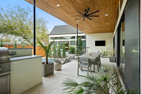 a living room with furniture a large window with kitchen view