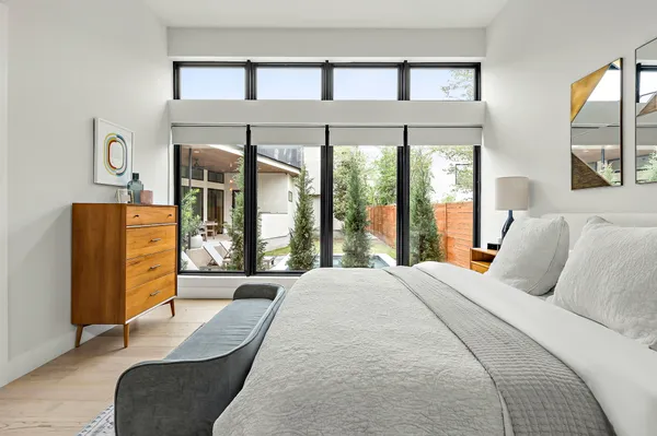a bedroom with furniture and large windows