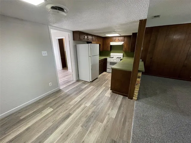 a kitchen with stainless steel appliances kitchen island granite countertop a refrigerator and a sink
