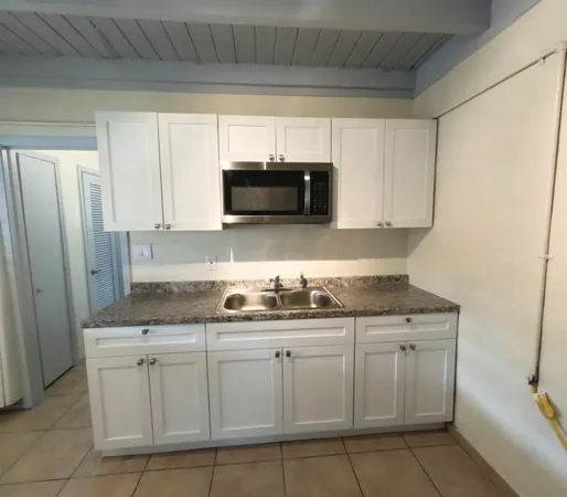 a kitchen with white cabinets and a sink