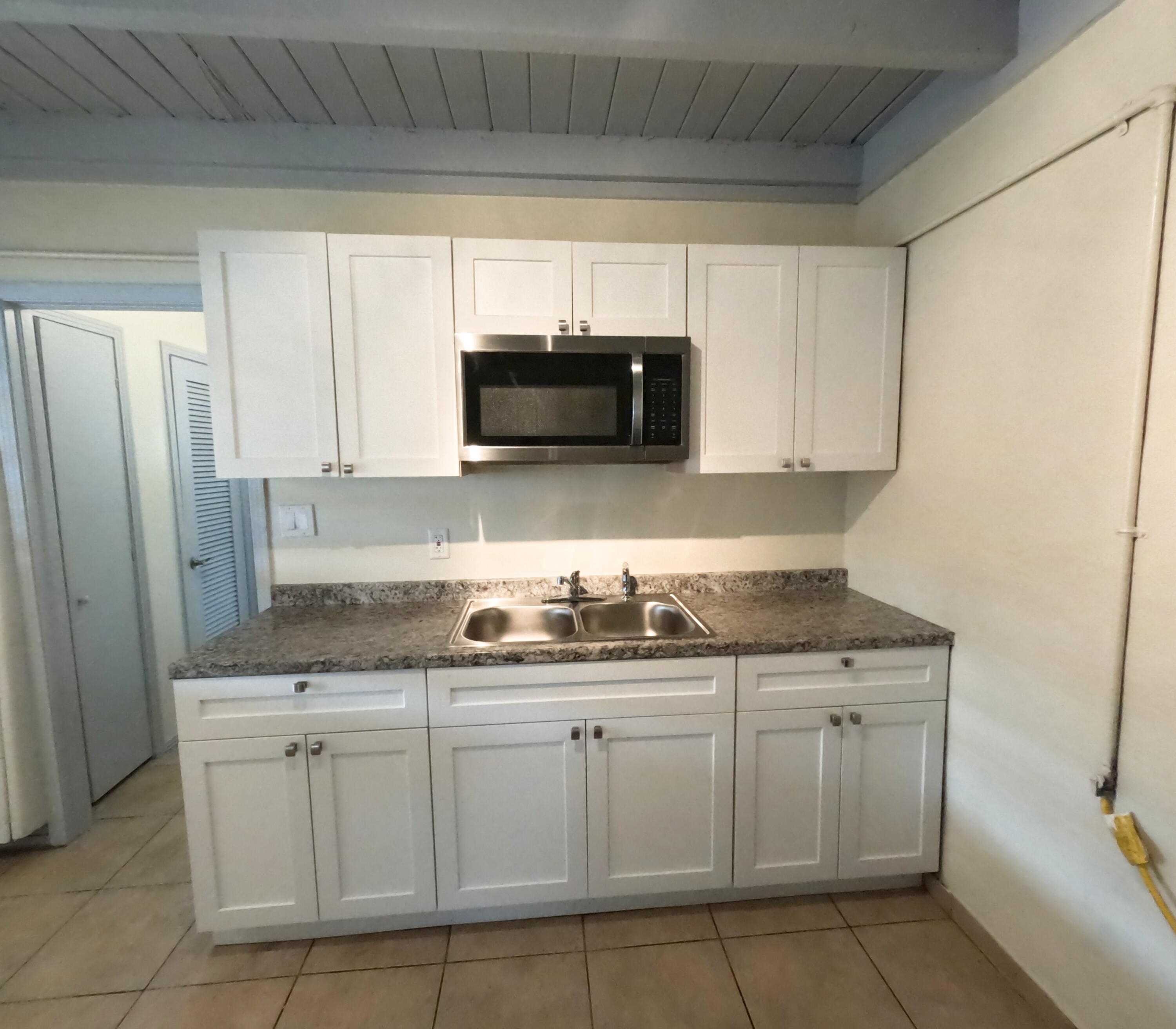 403 South 14th Street Fort Pierce, FL 34950 - Photo 3 of 19 a kitchen with white cabinets and a sink