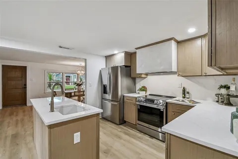 a kitchen with stainless steel appliances granite countertop a sink stove and refrigerator
