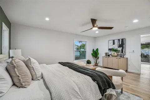 a view of a backyard with large trees and wooden fence