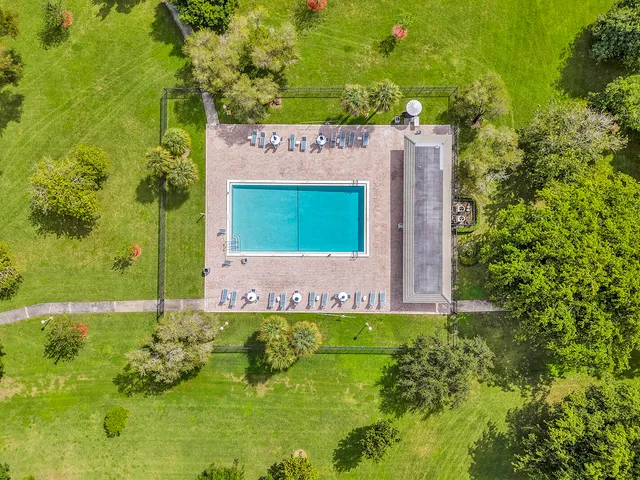 an aerial view of a swimming pool with a yard