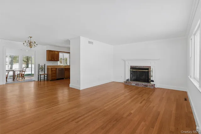 a view of empty room with wooden floor and fireplace