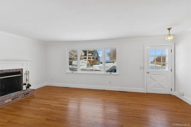 a view of empty room with wooden floor and fireplace
