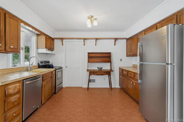a kitchen with stainless steel appliances granite countertop a refrigerator and a stove top oven