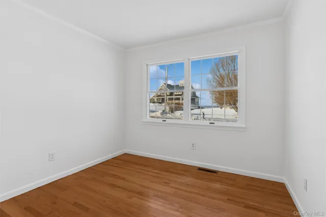 a view of a room with wooden floor and a window
