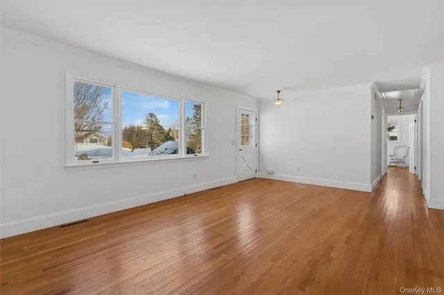 a view of a room with wooden floor and window