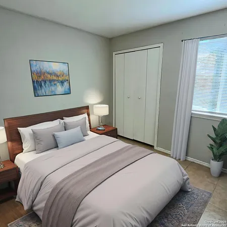 a bedroom with a large bed and a potted plant