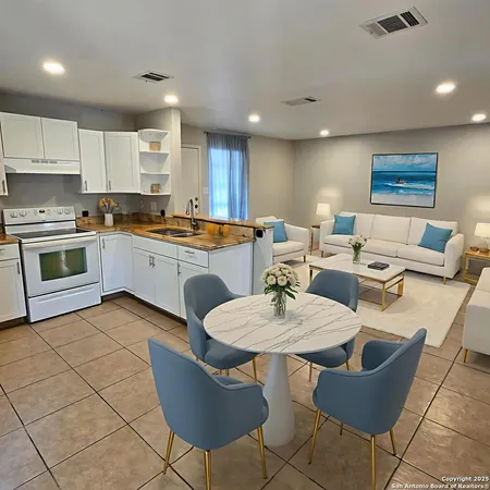 a open dining room with stainless steel appliances kitchen island granite countertop a table and chairs