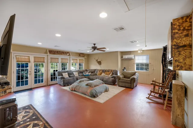 a living room with furniture large window and wooden floor