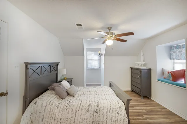 a bedroom with a large bed chandelier and a window
