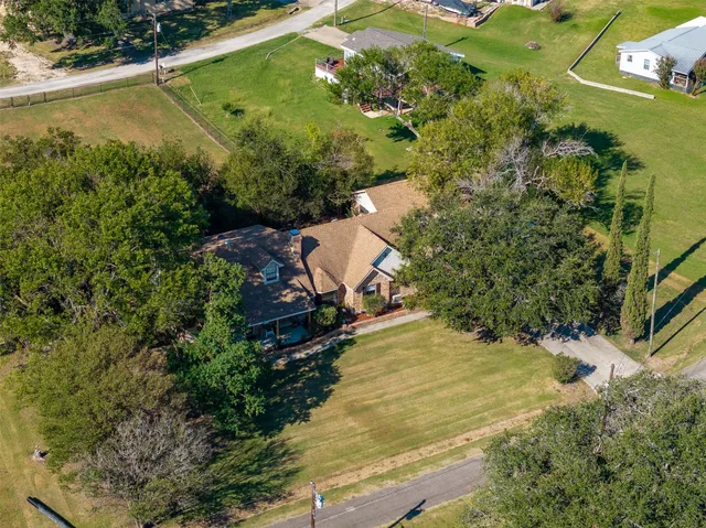 an aerial view of a house with a yard and lake view