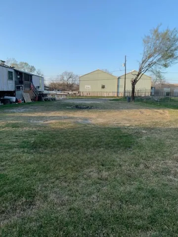 a view of a water house with a big yard and large trees