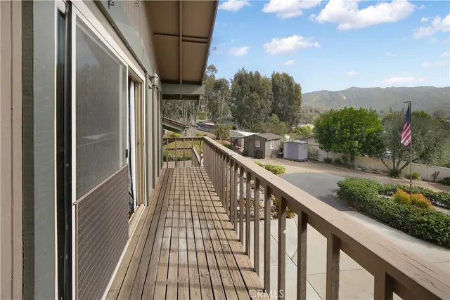 a view of a balcony with wooden floor and fence