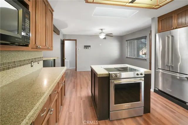 a kitchen with stainless steel appliances granite countertop a stove a sink and a refrigerator