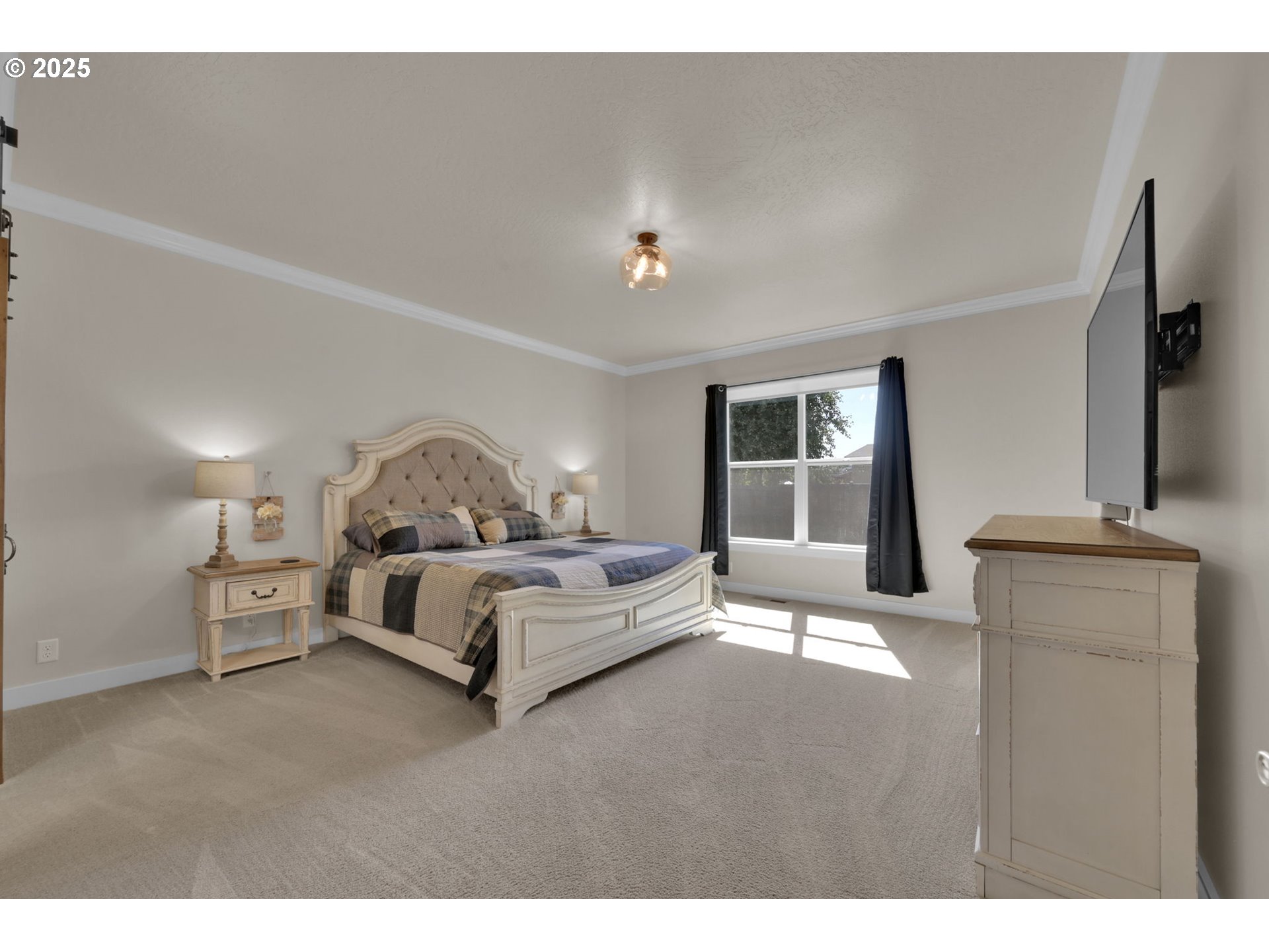 1004 South 46th Street Springfield, OR 97478 - Photo 15 of 34 a spacious bedroom with a bed and a flat screen tv