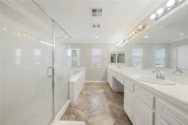 a large bathroom with a double vanity sink a large mirror and shower
