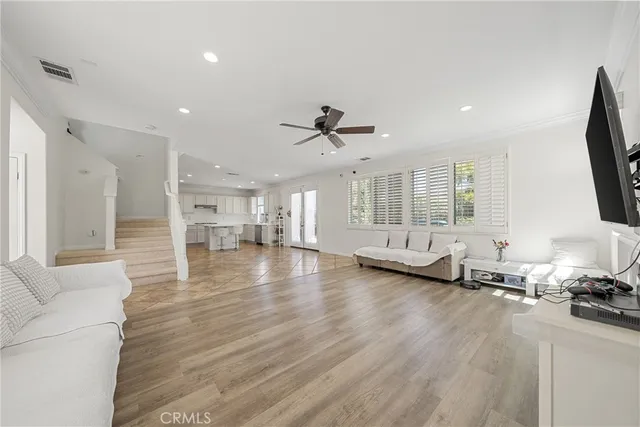 a view of a livingroom with furniture a ceiling fan and window