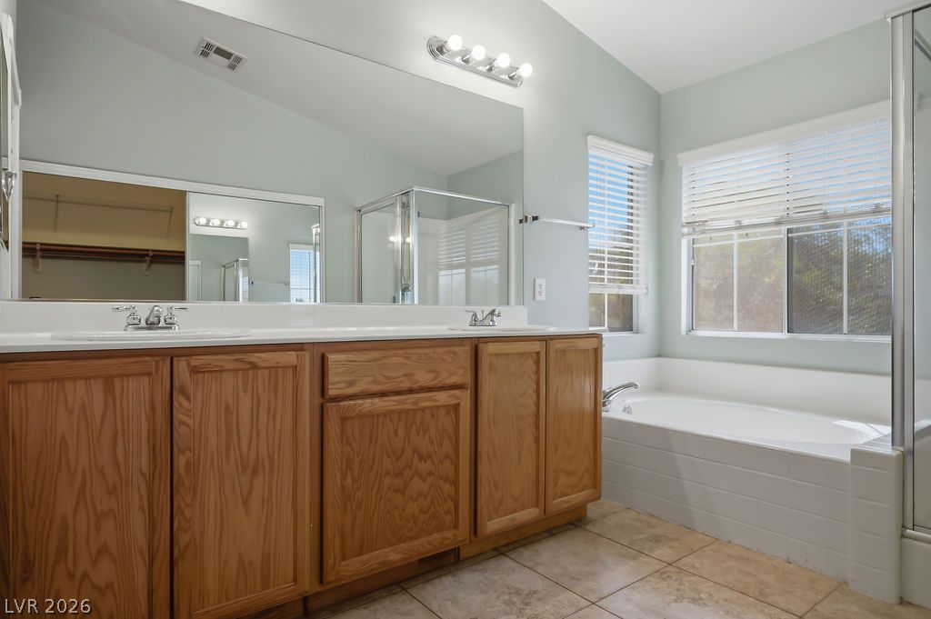 9712 North Running Rabbit Street Las Vegas, NV 89143 - Photo 33 of 42 Double vanity and a deep soaking tub create a private, relaxing space in this bathroom.