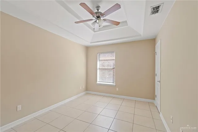 an empty room with windows and ceiling fan
