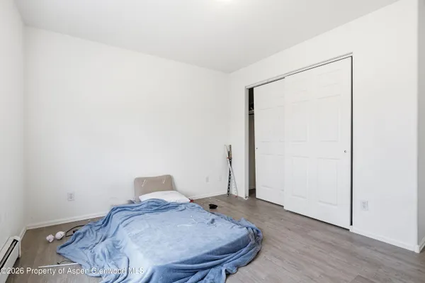a bedroom with a bed and wooden floor