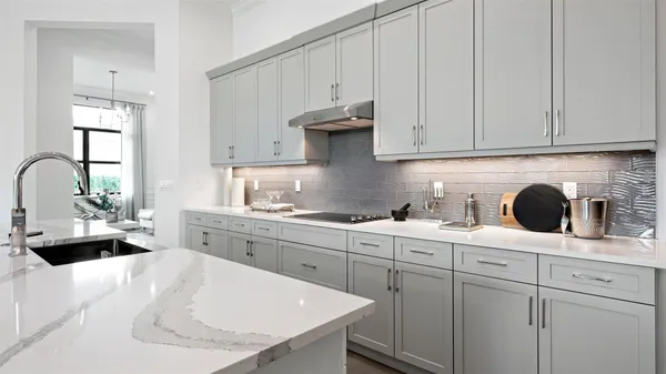 a kitchen with white cabinets a sink and dishwasher