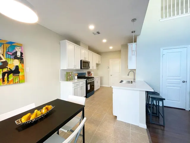 a kitchen with granite countertop a sink appliances and cabinets