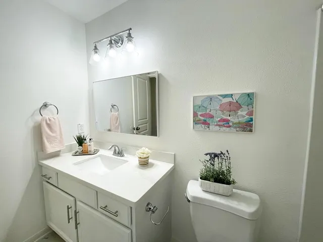 a bathroom with a toilet a sink and mirror