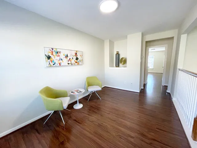 a view of a workspace with furniture and wooden floor