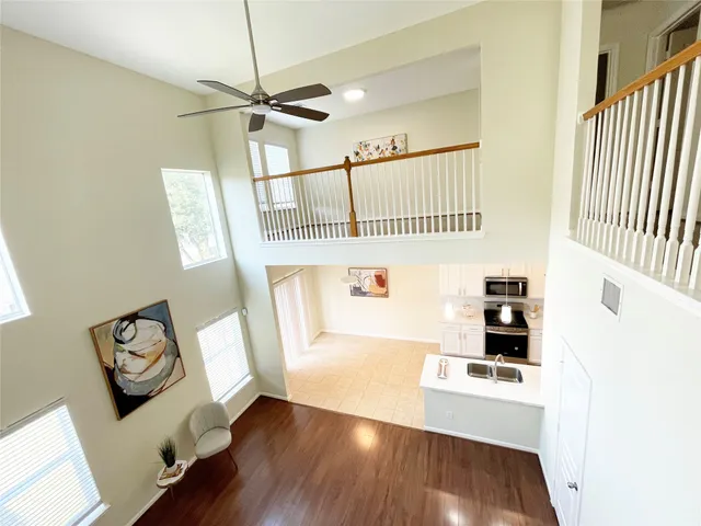 a view of a hallway with wooden floor and windows