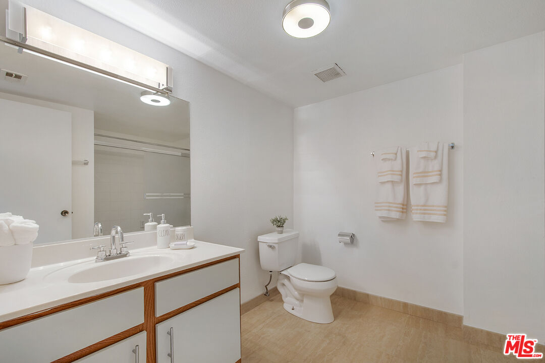 4451 Don Ricardo Drive, Unit 9 Los Angeles, CA 90008 - Photo 11 of 23 a bathroom with a toilet sink and mirror