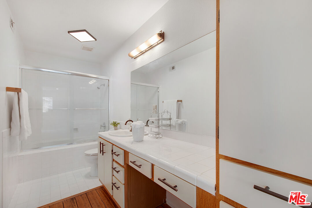 4451 Don Ricardo Drive, Unit 9 Los Angeles, CA 90008 - Photo 14 of 23 a bathroom with a sink a mirror and a bathtub