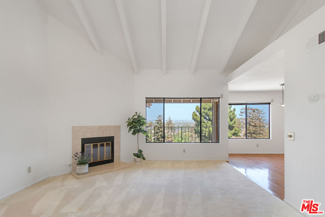 4451 Don Ricardo Drive, Unit 9 Los Angeles, CA 90008 - Photo 3 of 23 an empty room with windows and fireplace