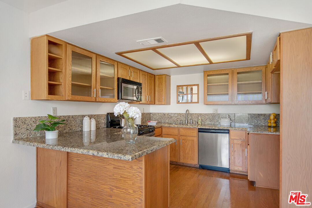 4451 Don Ricardo Drive, Unit 9 Los Angeles, CA 90008 - Photo 9 of 23 a kitchen with stainless steel appliances granite countertop a sink stove and cabinets