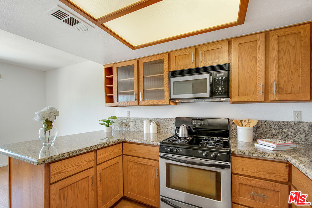 4451 Don Ricardo Drive, Unit 9 Los Angeles, CA 90008 - Photo 10 of 23 a kitchen with stainless steel appliances granite countertop a stove microwave and sink