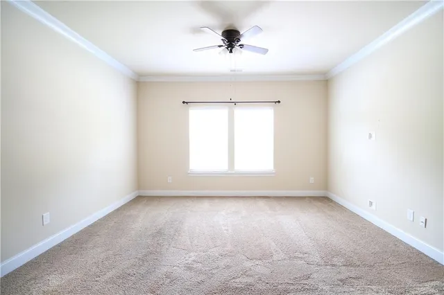 an empty room with a window and a ceiling fan