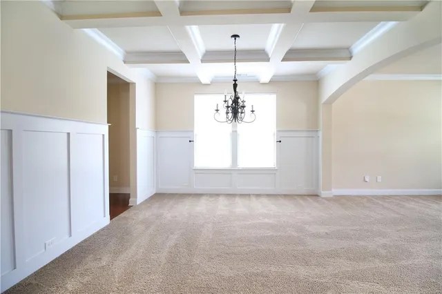 en empty room with windows and chandelier