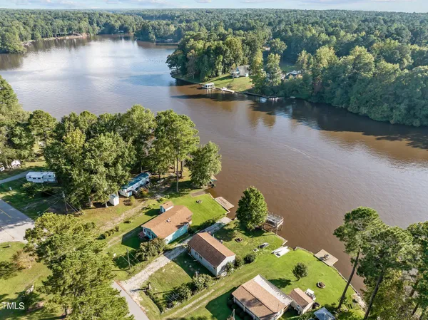 an aerial view of residential houses with outdoor space and lake view