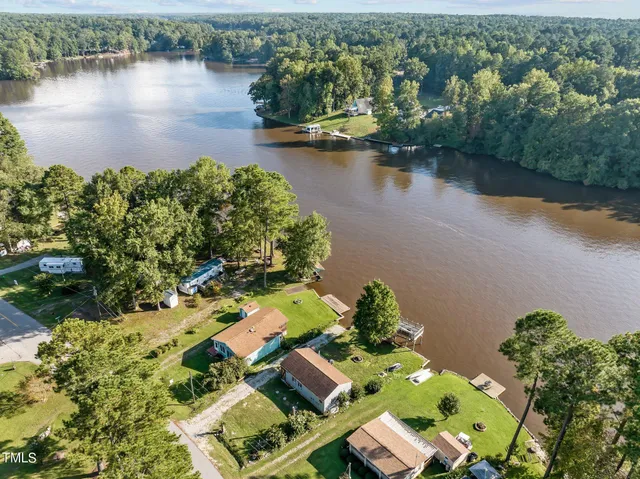 an aerial view of residential houses with outdoor space and lake view