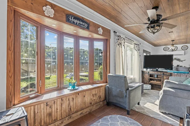 a living room with furniture a flat screen tv and a large window