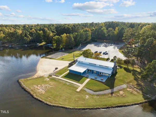 an aerial view of a house with a yard and lake view
