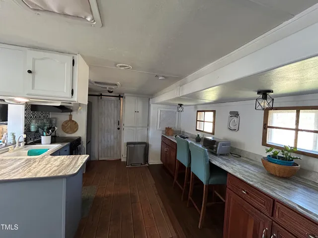 a kitchen with granite countertop lots of counter top space and living room
